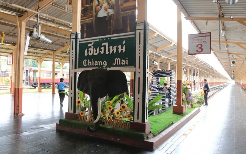 チェンマイ駅のホームに設置された象のオブジェと「Chiang Mai」の駅名を示す緑のボード。